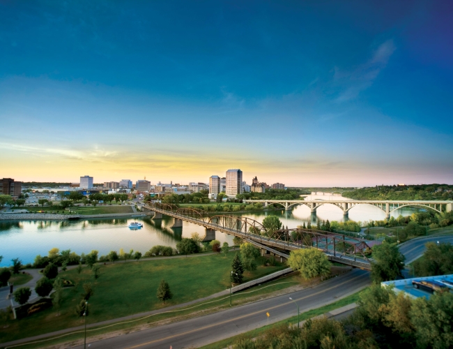 Aerial view of the city of Saskatoon with the highway in the foregound and the river and city in the background