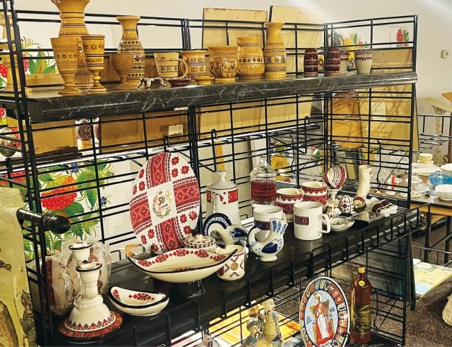 image of various Ukrainian plates, cups, and other dishes on a wire shelf