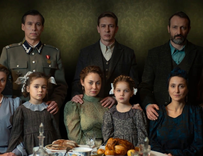 Image from the film Shchedryk (2022), which is showing at this year's festival. The image features three families sitting/standing around a table.