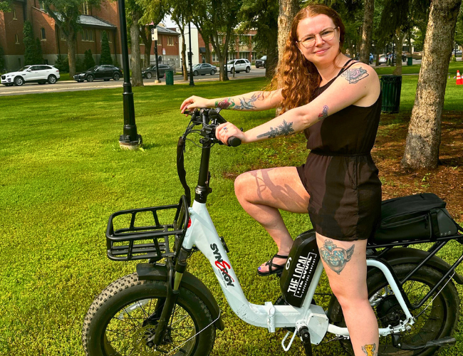 Person sitting on an e-bike, smiling for the camera