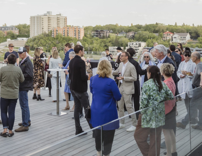 Friends gathering enjoying cocktails viewing the South Saskatchewan River from the rooftop terrace at Remai Modern.