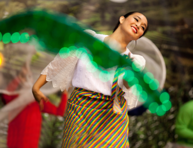 A dancer twirling with a green ribbon