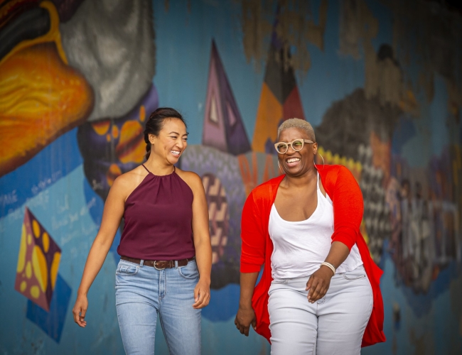 woman walking in front of a mural 