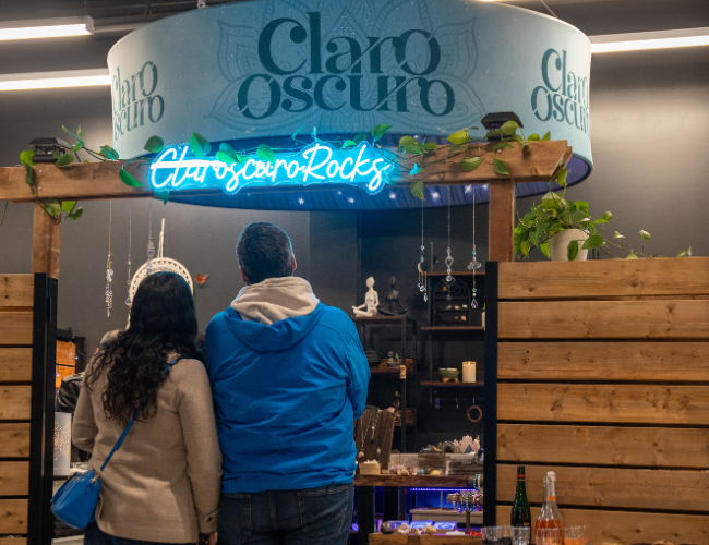 Two people standing in front of a sign that says Claroscuro