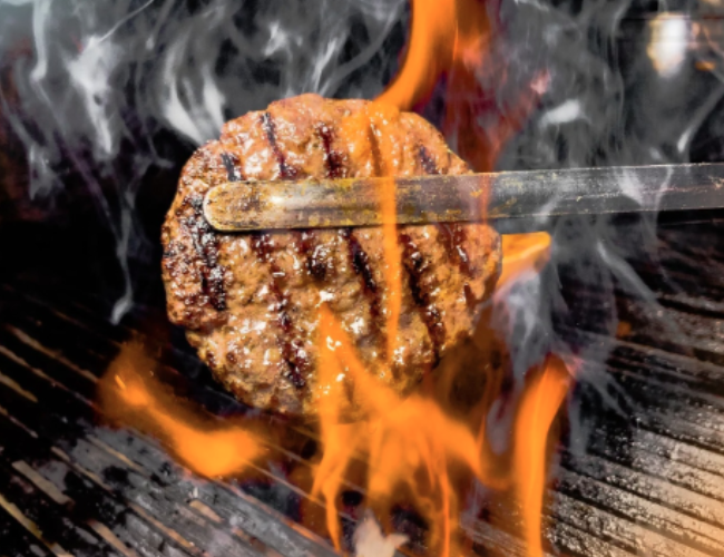 A burger patty being grilled.