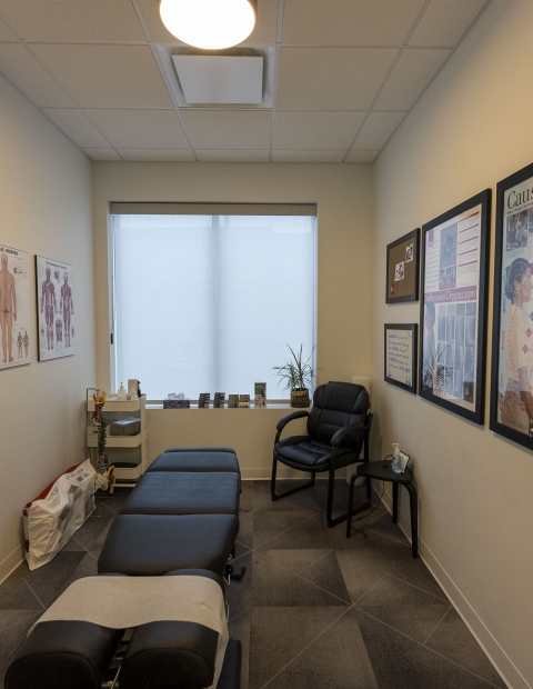 A chiropractic office with a massage table and chairs, providing a relaxing and therapeutic environment for patients.