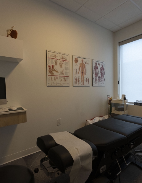 Interior of a chiropractors office with a desk and chair.