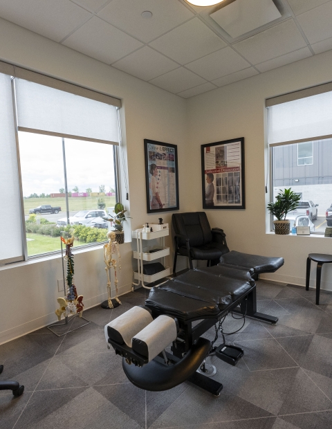 A chiropractic office with a desk and comfortable chairs for patients.