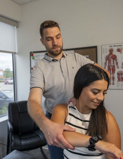 A chiropractor massaging a woman's arm.