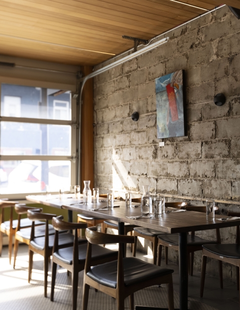 Rustic restaurant with stone wall and wooden tables