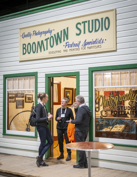 Three people conversing in front of the Boomtown Studio