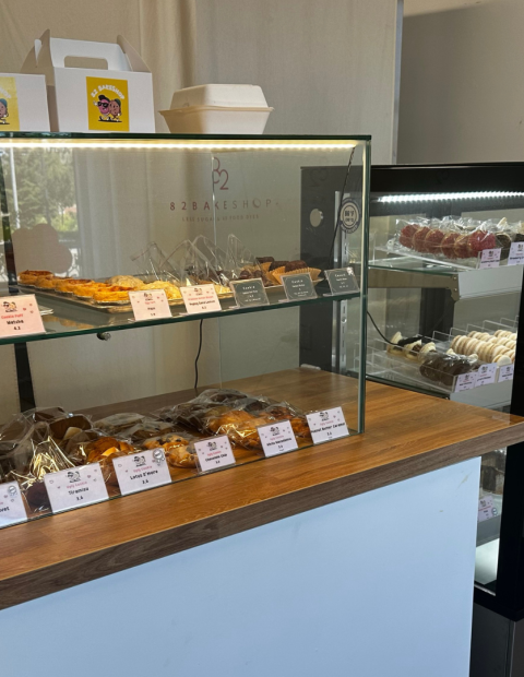 Two pastry enclosures filled with cookies and cheesecake